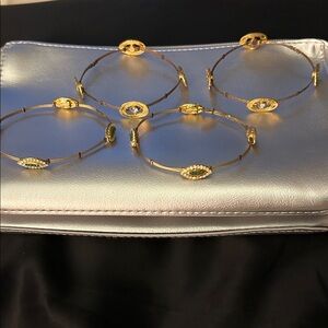 SEASONAL WHISPERS so of 4 gold bangle bracelets( Green and Clear Stones